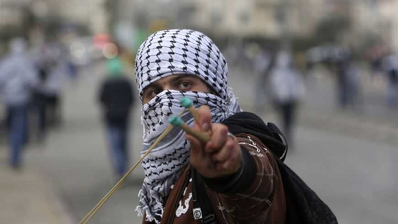 A Palestinian uses a slingshot to hurl a stone towards Israeli troops during clashes near Ramallah A Palestinian uses a slingshot to hurl a stone towards Israeli troops during clashes outside Israel's Ofer military prison near the West Bank city of Ramallah February 28, 2013. The death of a Palestinian prisoner in disputed circumstances in an Israeli jail on Saturday, together with a hunger strike by four other Palestinian inmates, have touched off violent protests over the past several weeks outside the prison and in West Bank towns. REUTERS/Mohamad Torokman (WEST BANK - Tags: POLITICS CIVIL UNREST) - R