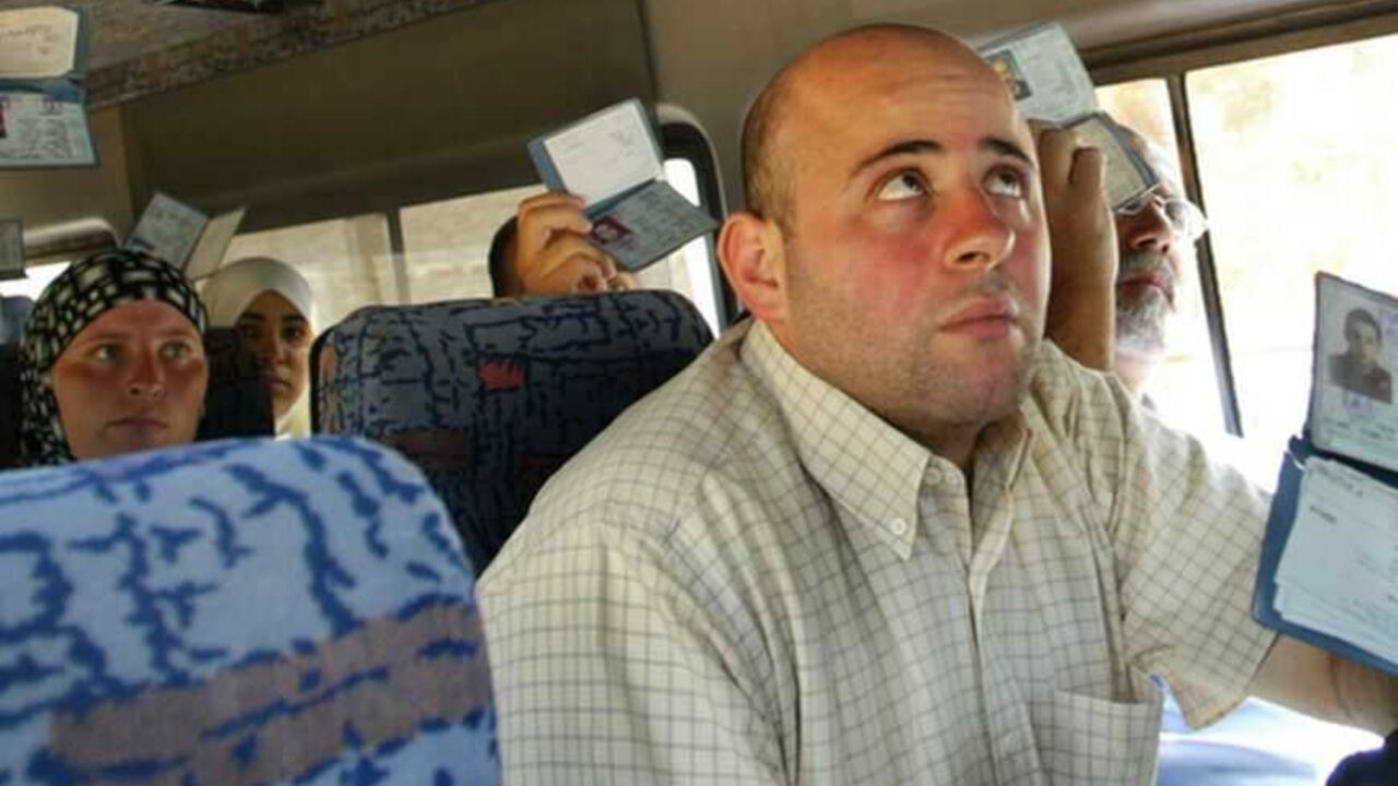Palestinians show ID cards to Israeli policeman inside bus in Jerusalem. Palestinians show their ID cards to Israeli police inside a bus in Jerusalem August 12, 2004. Investigators were still examining if members of a militant cell which bombed a West Bank checkpoint Wednesday were still at large. The blast killed two Palestinians and wounded 16 people. REUTERS/Gil Cohen Magen GCM/SM - RTR8GY0