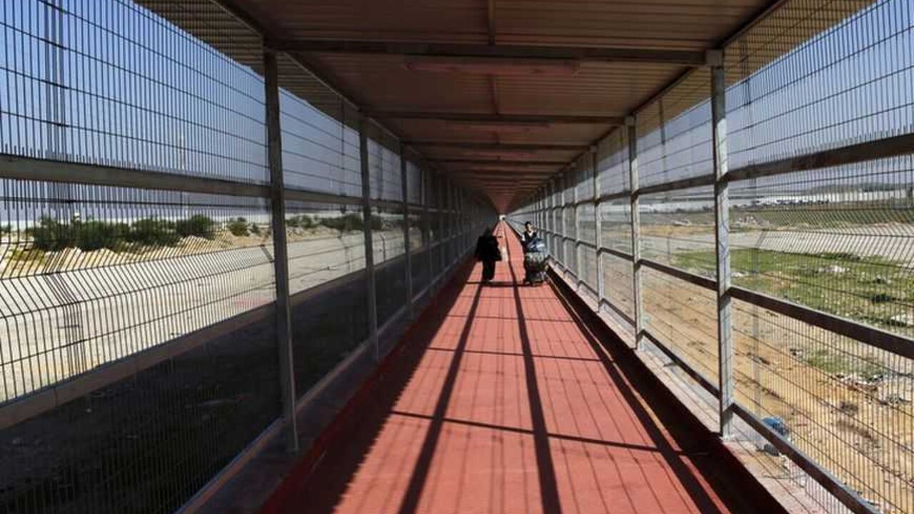 Palestinians walk through a passage way on way back to Gaza Palestinians walk through a newly built 500 meter-long passage way on their way back to the Gaza Strip through Israel's Erez Crossing December 3, 2009. REUTERS/Yannis Behrakis (GAZA POLITICS) - RTXRERB