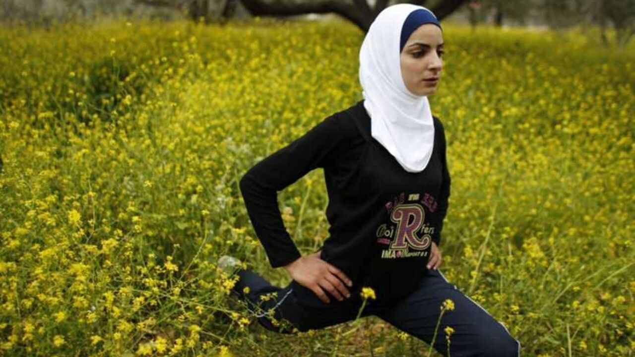 Palestinian runner Maslaha stretches as she practises at a field belonging to her family near Nablus Palestinian runner Worood Maslaha, 20, stretches as she practises with her trainer Saher Jura (unseen) at a field belonging to her family in the West Bank village of Asira Ash-Shamaliya near Nablus March 27, 2012. Four Palestinians will participate in the London Olympics and joining Maslaha will be Gaza runner Bahaa al-Farra, Cairo-based swimmer Ahmed Jabreel and swimmer Sabeen Kharyoon from Bethlehem. Picture taken March 27, 2012. REUTERS/Ammar Awad (WEST BANK - Tags: SPORT OLYMPICS ATHLETICS) - RTR3001Q