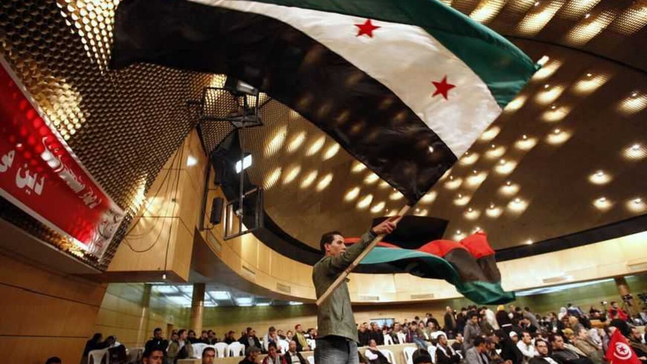 A supporter holds a Syrian opposition flag during a demonstration at the Ennahda party "Youth Festival" organized by the Renaissance Movement at the Conference Palace in Tunis A supporter holds a Syrian opposition flag during a demonstration at the Ennahda party "Youth Festival" organized by the Renaissance Movement at the Conference Palace in Tunis December 23, 2012. The event is part of a celebration for the second anniversary of the Tunisian revolution. REUTERS/Anis Mili (TUNISIA - Tags: POLITICS CIVIL UNREST ANNIVERSARY) - RTR3BV0G