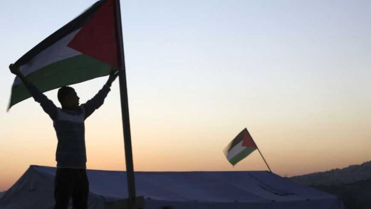 An activist holds a Palestinian flag placed near a newly-erected tent between Ramallah and Jerusalem An activist holds a Palestinian flag placed near a newly-erected tent in the West Bank village of Beit Iksa, between Ramallah and Jerusalem January 20, 2013. Palestinians pitched tents in an area of the West Bank as a protest against an Israeli barrier they said would cut villagers off from their lands. The tents were erected on Friday in the Palestinian village of Beit Iksa, north of Jerusalem. REUTERS/Mohamad Torokman (WEST BANK - Tags: POLITICS) - RTR3CPAC