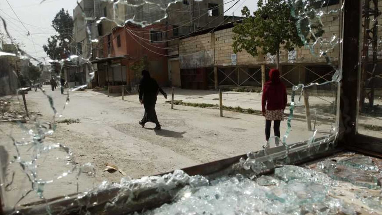Women are seen through a broken window after clashes at Ain al-Hilweh Palestinian refugee camp near the port city of Sidon Women are seen through a broken window after clashes at Ain al-Hilweh Palestinian refugee camp near the port city of Sidon in south Lebanon March 12, 2013. Ten people were wounded and one killed during clashes between the Fatah movement and radical Islamists that started on Monday. REUTERS/Ali Hashisho (LEBANON - Tags: POLITICS CIVIL UNREST) - RTR3EW46