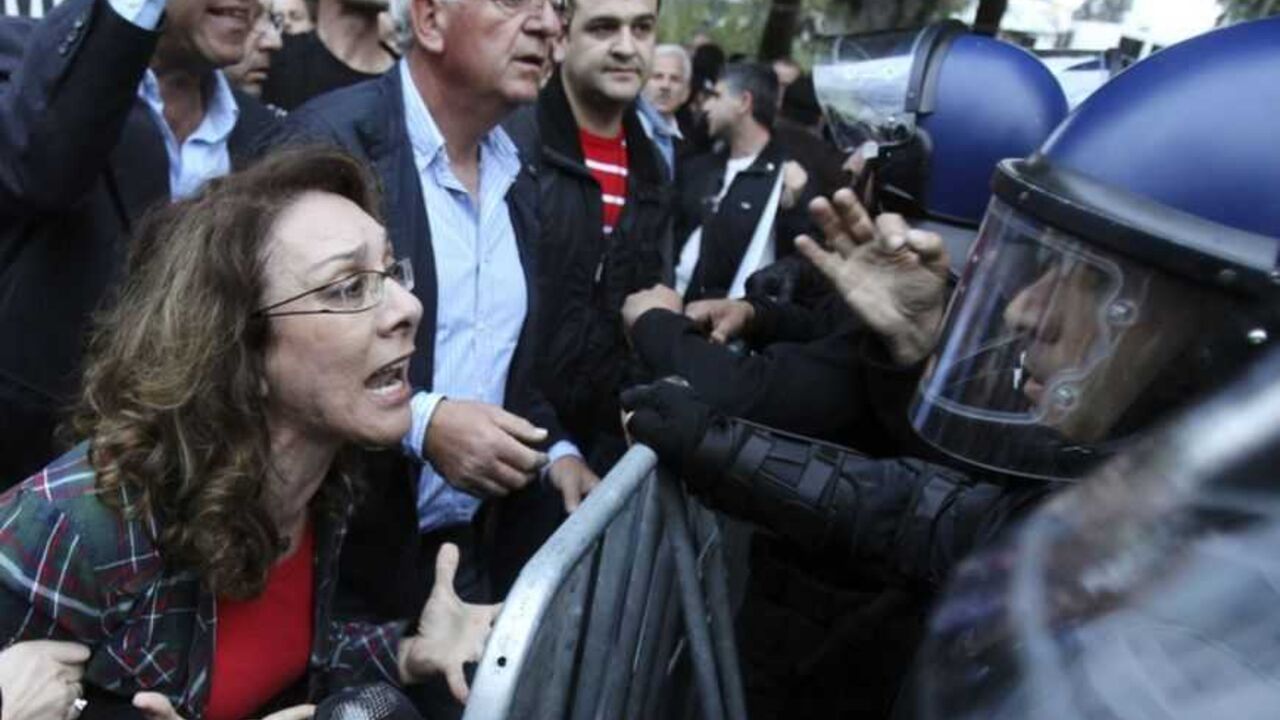 A protester yells at policemen during a protest by employees of Cyprus Popular Bank outside the parliament in Nicosia A protester yells at policemen during a protest by employees of Cyprus Popular Bank outside the parliament in Nicosia March 21, 2013. The Cypriot central bank denied reports and frantic rumours on Thursday that stricken Cyprus Popular Bank, the island's second-largest lender, is to be closed down. REUTERS/Andreas Manolis (CYPRUS - Tags: POLITICS BUSINESS CIVIL UNREST TPX IMAGES OF THE DAY) - RTR3FA5X