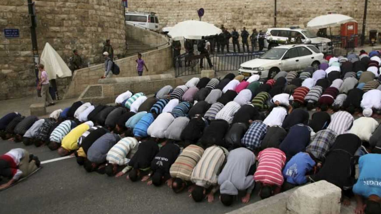 Palestinians pray near Israeli policemen outside Jerusalem's Old City Palestinians pray near Israeli policemen outside Jerusalem's Old City March 22, 2013. Israeli police declared an age limit on Friday for Palestinians wanting to enter the Old City, only allowing males above the age of 50 and all females to enter. REUTERS/Muammar Awad (JERUSALEM - Tags: POLITICS RELIGION) - RTR3FBXC