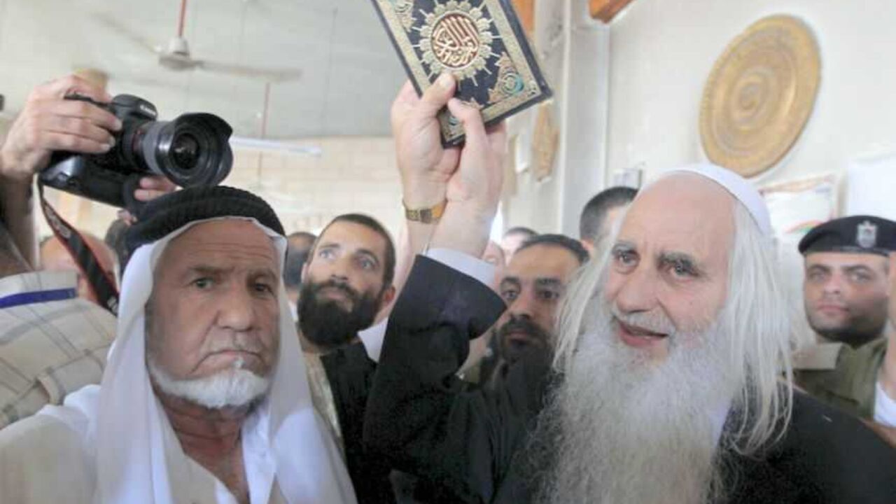 Rabbi and peace activist Froman holds a Koran given to Palestinians near Bethlehem Rabbi and peace activist Menachem Froman (R) holds a Koran as it is given to Palestinians at a mosque after Monday's attack in the West Bank village of Beit Fajjar near Bethlehem October 5, 2010. Jewish settlers on Tuesday gave Korans to Palestinians in the West Bank village whose mosque was burned in an attack blamed on militants in the settler movement. REUTERS/Ammar Awad (WEST BANK - Tags: POLITICS CIVIL UNREST RELIGION) - RTXT2UB