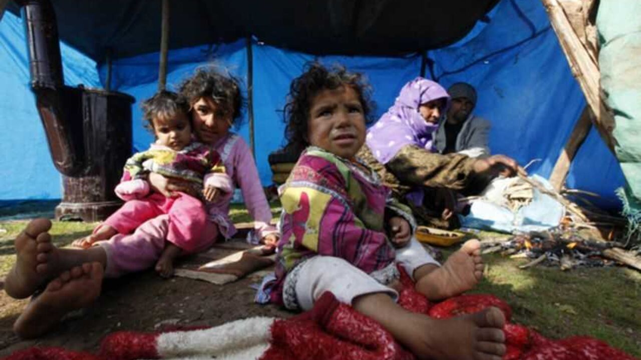 A Syrian refugee family sits in front of their makeshift tent in the town of Viransehir in Sanliurfa province A Syrian refugee family sits in front of their makeshift tent in the town of Viransehir in Sanliurfa province, southeast Turkey, February 10, 2013. Some 50 families, mostly from villages near Syria's Aleppo, prefer to settle in the outskirts of Viransehir instead of refugee camps run by the Turkish government. According to the families, this allows them to work as seasonal agricultural workers. REUTERS/Umit Bektas (TURKEY - Tags: POLITICS SOCIETY IMMIGRATION BUSINESS EMPLOYMENT CIVIL UNREST) - RTR3DL1D