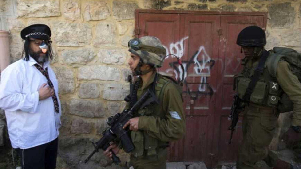 A Jewish settler, dressed in costume, stands near Israeli soldiers as they guard a parade for the holiday of Purim in Hebron A Jewish settler, dressed in costume, stands near Israeli soldiers as they guard a parade for the holiday of Purim in the West Bank city of Hebron February 24, 2013. Purim is a celebration of the Jews' salvation from genocide in ancient Persia, as recounted in the Book of Esther. REUTERS/Ronen Zvulun (WEST BANK - Tags: SOCIETY RELIGION MILITARY TPX IMAGES OF THE DAY) - RTR3E7ED