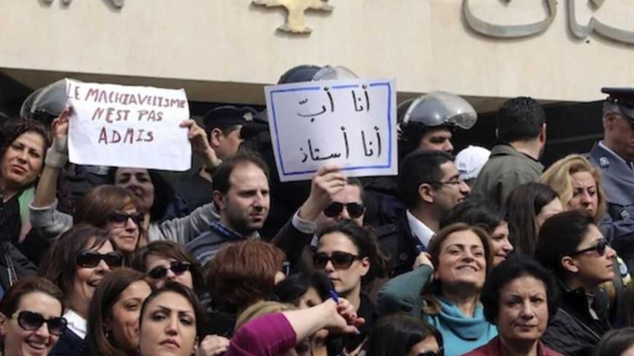 Protesters carry banners outside the Lebanese Central Bank in Beirut Protesters carry banners outside the Lebanese Central Bank in Beirut February 25, 2013. An open-ended strike by teachers and civil servants entered its second week today for the government to approve the wage hike proposal. The banners read " I am a father, I am a teacher" and " Machiavellism is not permited " REUTERS/Mohamed Azakir (LEBANON - Tags: POLITICS CIVIL UNREST) - RTR3E9TN