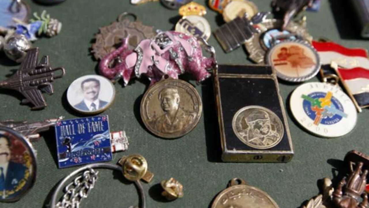 A vendor displays items showing former Iraqi President Saddam Hussein at the Bab al-Sharji market in central Baghdad March 15, 2013. REUTERS/Saad Shalash (IRAQ - Tags: CONFLICT SOCIETY POLITICS) - RTR3F0ZJ