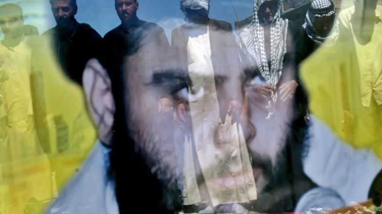 Iraqi worshippers perform Friday Prayers in Baghdad. Iraqi Muslim worshippers, reflected on a portrait of the Shi'ite cleric Muqtada al-Sadr, perform Friday Prayers outside al-Sadr's office in eastern Baghdad March 25, 2005. REUTERS/Ali Jasim HH/CCK - RTR61YO