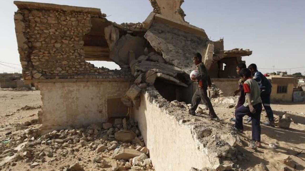 IRAQ/ Iraqi boys walk near the ruins of a building, which residents and the Local Council claim was bombed during the 2003 Iraq War led by the U.S. forces, in a desert south of Samawa, 270 km (160 miles) south of Baghdad March 14, 2013. Iraq marked the 10th anniversary of the U.S.-led invasion that ousted Saddam Hussein on Tuesday. Picture taken March 15, 2013. REUTERS/Mohammed Ameen (IRAQ - Tags: CONFLICT CIVIL UNREST ANNIVERSARY) - RTR3F899