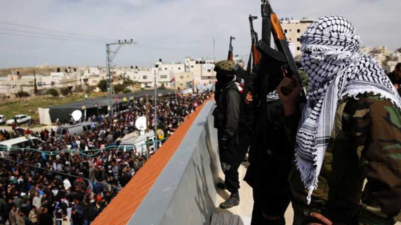 Masked Palestinian gunmen hold weapons atop a roof during the funeral of Arafat Jaradat in the West Bank village of Se'eer, near Hebron Masked Palestinian gunmen hold weapons atop a roof during the funeral of Arafat Jaradat in the West Bank village of Se'eer, near Hebron February 25, 2013. Jaradat's death in an Israeli jail on Saturday and a hunger strike by four other Palestinian inmates have raised tension in the occupied territory after repeated clashes between stone-throwers and Israeli soldiers in recent days. Israeli troops, on high alert, took up positions outside Jaradat's home village of Se'eer, in likely earshot of the bursts of a