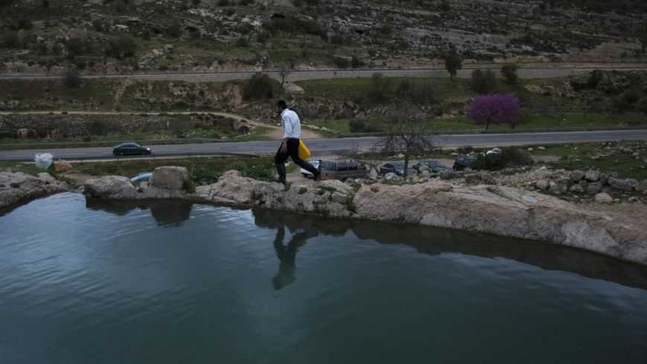 An Ultra-Orthodox Jewish man walks next to a spring water reservoir near Jerusalem An Ultra-Orthodox Jewish man walks next to a spring water reservoir before taking part in the ritual of "Mayim Shelanu" near Jerusalem March 17, 2013. The water is used to prepare matza, traditional unleavened bread eaten during the upcoming Jewish holiday of Passover. Passover commemorates the flight of Jews from ancient Egypt, as described in the Exodus chapter of the Bible. REUTERS/Ronen Zvulun (WEST BANK - Tags: RELIGION) - RTR3F4JW