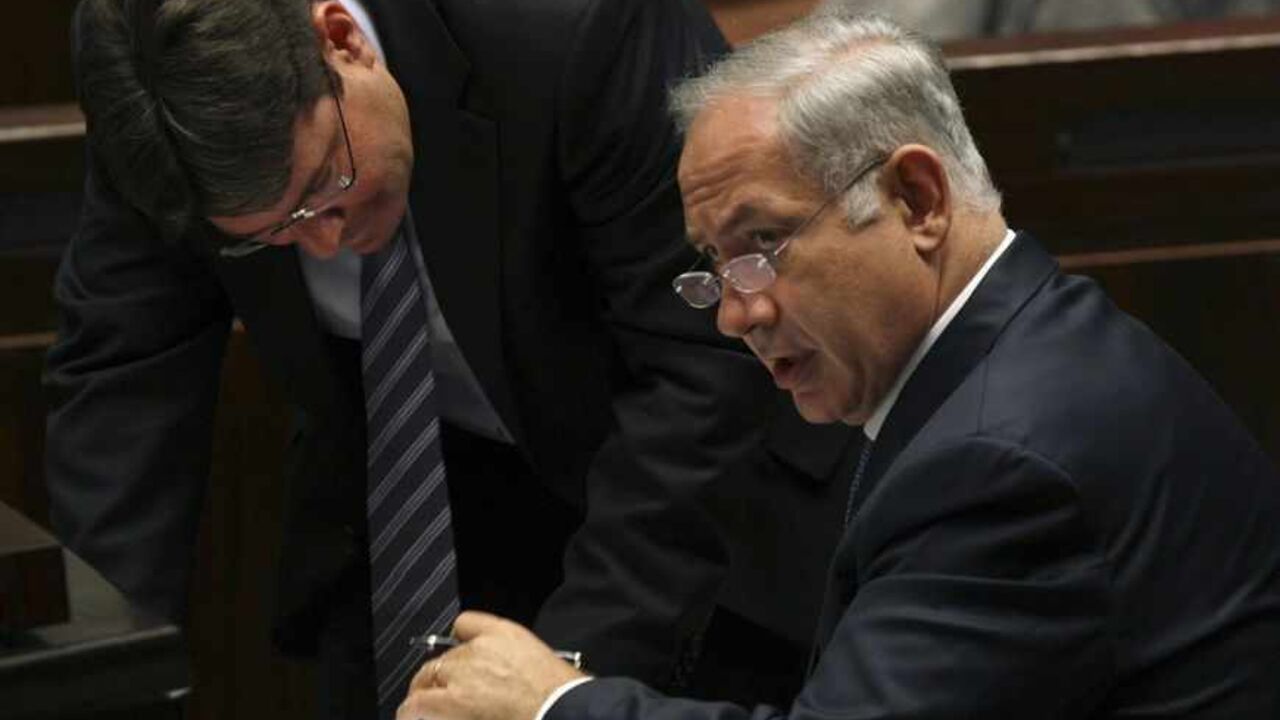 Israel's Prime Minister Netanyahu speaks with Knesset member Akonis at the Knesset in Jerusalem Israel's Prime Minister Benjamin Netanyahu (R) speaks with Knesset member Ofir Akonis after a non-confidence vote at the Knesset, the Israeli parliament, in Jerusalem June 8, 2009. Netanyahu plans to deliver a major policy speech on Sunday aimed at addressing U.S. demands that he freeze settlement building and agree to negotiations on establishing a Palestinian state. REUTERS/Ronen Zvulun (JERUSALEM POLITICS) - RTR24G6O