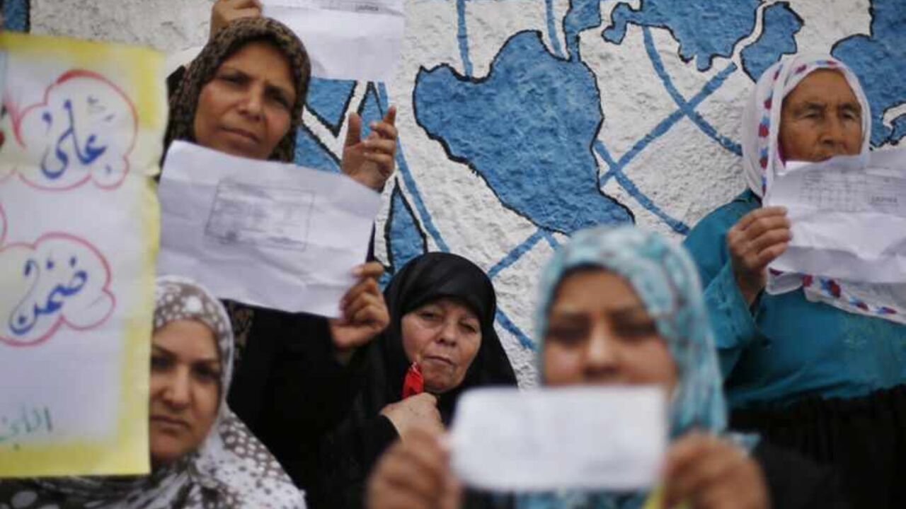 Palestinian women hold up their refugee ration cards during a protest demanding the UNRWA to resume aid for refugees in Gaza City Palestinian women hold up their refugee ration cards during a protest demanding the United Nations Relief and Works Agency (UNRWA) to resume aid for refugees in Gaza City April 8, 2013. The main U.N. humanitarian agency for Palestinians closed all of its relief and distribution centres in Gaza after protesters stormed its headquarters on Thursday demanding it to reverse a decision to cut annual cash handouts of $40 to the poorest beneficiaries. REUTERS/Suhaib Salem (GAZA - Tags: POLITICS CIVIL UNREST SOCIET