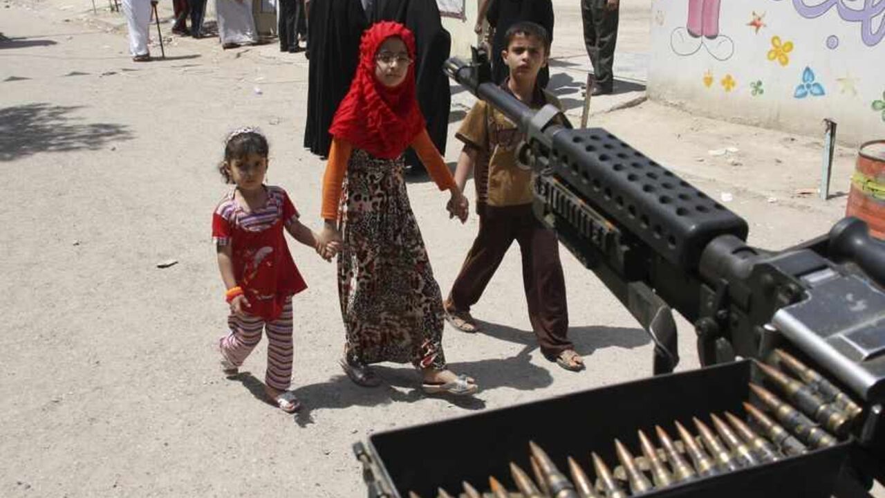 Children walk by a machine-gun near election centre in Baghdad Children walk by a machine-gun near election centre in Baghdad April 20, 2013. Iraqis voted for provincial councils on Saturday in their first ballot since U.S. troops left the country, a key measure of political strength before parliamentary elections next year. Iraqi politics are deeply split along sectarian lines with Prime Minister Nuri al-Maliki's government mired in crisis over how to share power among Shi'ites, Sunni Muslims and ethnic Kurds who run their own autonomous region in the north. Violence