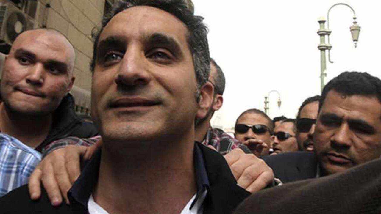 EGYPT-ARREST/SATIRIST Bassem Youssef (C), the country's best-known satirist, gestures to journalists and activists as he arrives at the high court to appear at the prosecutor's office in Cairo March 31, 2013. Egypt's prosecutor-general on Saturday ordered the arrest of Youssef for making fun of Islamist President Mohamed Mursi and his Muslim Brotherhood. REUTERS/Mohamed Abd El Ghany (EGYPT - Tags: POLITICS CRIME LAW SOCIETY) - RTXY3QR