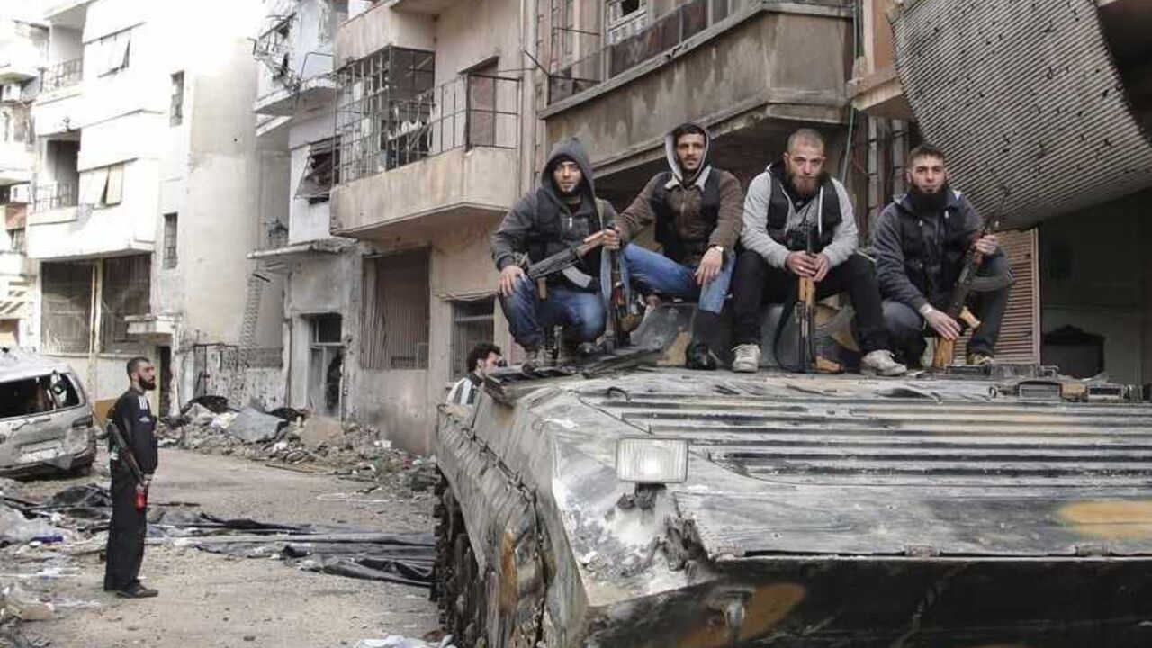 SYRIA-CRISIS/ Free Syrian Army fighters pose for a picture on a tank, that they claim to have seized from the Syrian Regime forces, in Homs April 5, 2013 in this picture provided by Shaam News Network. Picture taken April 5, 2013. REUTERS/Mohamed Ibrahim/Shaam News Network/Handout (SYRIA - Tags: POLITICS CIVIL UNREST CONFLICT MILITARY)
ATTENTION EDITORS - THIS PICTURE WAS PROVIDED BY A THIRD PARTY. REUTERS IS UNABLE TO INDEPENDENTLY VERIFY THE AUTHENTICITY, CONTENT, LOCATION OR DATE OF THIS IMAGE. THIS PICTURE IS DISTRI