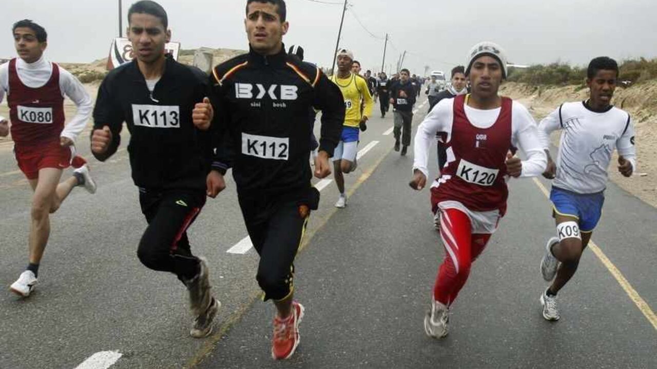 PALESTINIANS/ Runners take part in a 10 km race, as part of the second annual Gaza Marathon, organized by the United Nations Relief and Works Agency (UNRWA) in Khan Younis, in the southern Gaza Strip March 1, 2012. According to UNWRA, nearly 2,000 runners, Palestinians, foreigners and children, took part in the Gaza running events on Thursday, held to raise funds for the agency's 2012 Summer Games. REUTERS/Ibraheem Abu Mustafa (GAZA - Tags: SPORT POLITICS) - RTR2YOBB