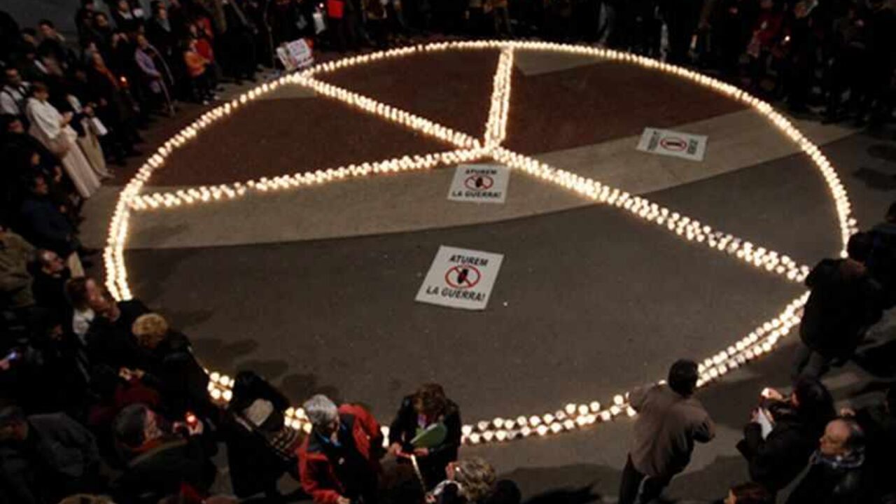 SPAIN-BARCELONA/ Members from peace groups gather around a peace sign formed by lighted candles, remembering the tenth anniversary of the Iraq War at Plaza de Catalunya, central Barcelona March 20, 2013. REUTERS/Gustau Nacarino (SPAIN - Tags: CIVIL UNREST) - RTR3F8PV
