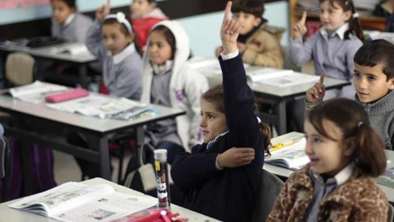 ISRAEL-PALESTINIANS/SCHOOL Palestinian first-graders sit with their schoolbooks during class in the West Bank city of Ramallah February 4, 2013. Israelis and Palestinians depict each other in schoolbooks as an enemy and largely deny their adversary's history and existence, according to a U.S. government-funded study published on Monday. REUTERS/Mohamad Torokman (WEST BANK - Tags: EDUCATION POLITICS) - RTR3DCHK