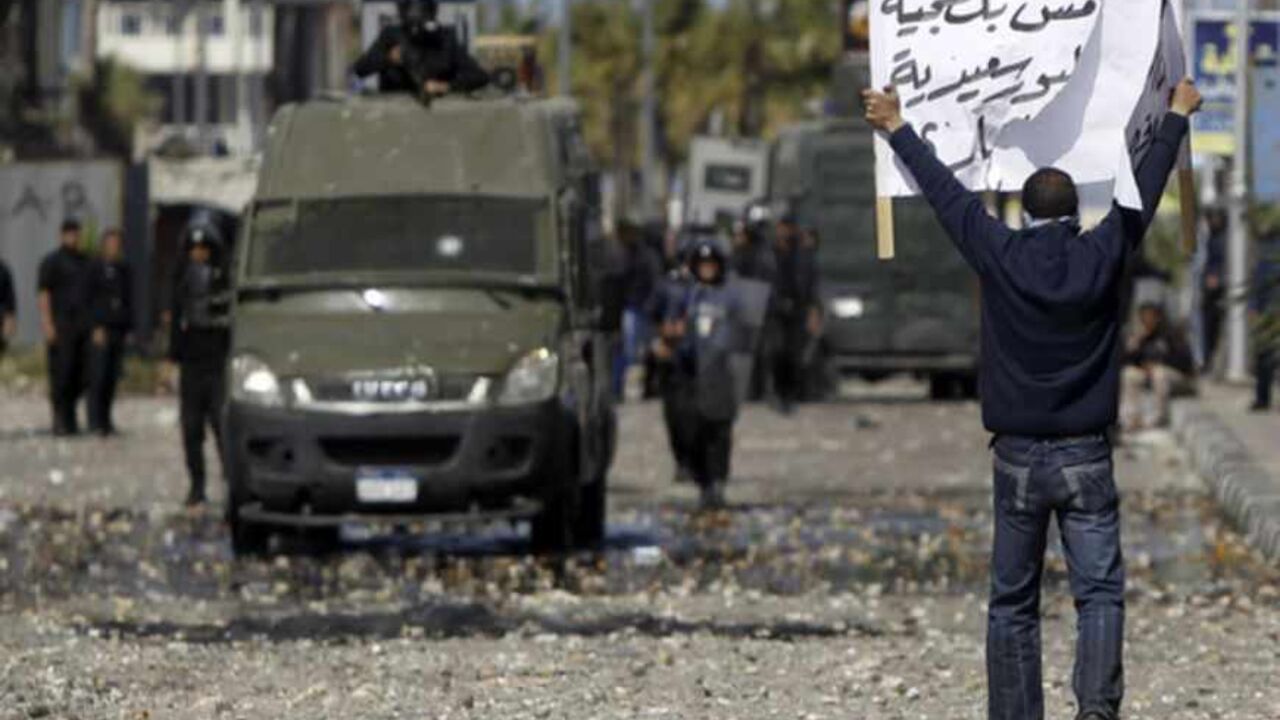 A riot policeman releases tear gas at protesters opposing Egyptian President Mohamed Mursi during clashes in front of Security Directorate in Port Said city A protester opposing Egyptian President Mohamed Mursi holds up a sign during clashes in front of the Security Directorate in Port Said city, 170 km (105 miles) northeast of Cairo March 5, 2013. Egyptian security forces battled stone-throwing youths in the Suez Canal city of Port Said on Tuesday while in Cairo even police staged a protest, reflecting a country beset by discontent over a host of grievances. The sign reads "Port Said not thugs, this is our freedom". REUTERS/Amr Abdallah Dalsh (EGYPT - Tags: P