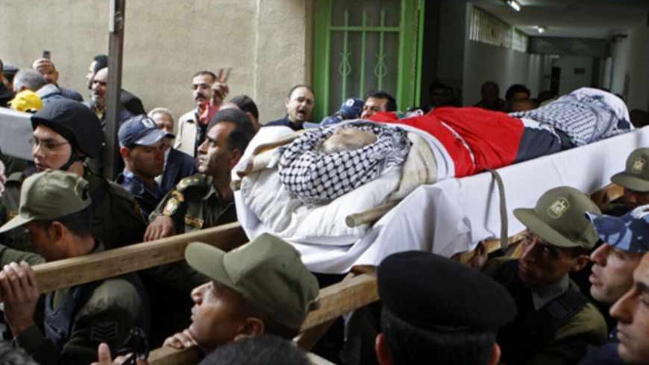 Members of the Palestinian security forces carry the body of Abu Hamdeya out of a hospital before his funeral Hebron Members of the Palestinian security forces carry the body of Maysara Abu Hamdeya out of a hospital before his funeral in the West Bank city of Hebron April 4, 2013. Tensions have risen rapidly in the West Bank and Gaza Strip following the death from cancer on Tuesday of Abu Hamdeya, 64, who was serving a life sentence in an Israeli jail. REUTERS/Mussa Qawasma (WEST BANK - Tags: POLITICS CIVIL UNREST) - RTXY7TG