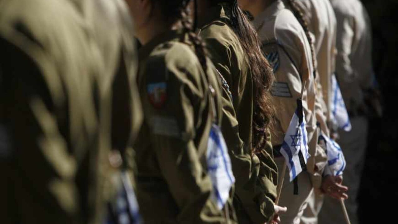 Israeli soldiers hold flags near graves of fallen soldiers at Mount Herzl military cemetery in Jerusalem, ahead of Memorial Day Israeli soldiers hold flags before placing them on the graves of fallen soldiers during a ceremony at the Mount Herzl military cemetery in Jerusalem, ahead of Memorial Day, April 10, 2013. Israel commemorates its fallen soldiers on Memorial Day, which begins Sunday night. REUTERS/Ronen Zvulun (JERUSALEM - Tags: POLITICS ANNIVERSARY CONFLICT) - RTXYGCO