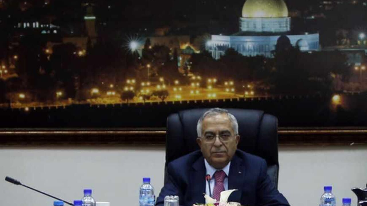 Palestinian Prime Minister Salam Fayyad sits at the head of a Palestinian cabinet meeting in the West Bank city of Ramallah Palestinian Prime Minister Salam Fayyad sits at the head of a Palestinian cabinet meeting in the West Bank city of Ramallah April 16, 2013. Abbas accepted Fayyad's resignation on Saturday, but is likely to keep him in office for the next few weeks while the U.S. tries to revive Middle East peace talks, officials said on Monday. REUTERS/ Mohamed Torokman (WEST BANK - Tags: POLITICS) - RTXYNV1