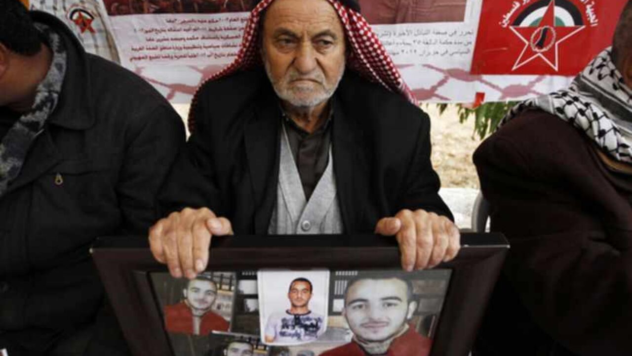 A Palestinian man holds photographs during a rally marking Prisoner Day in Hebron A Palestinian man holds photographs of his relative who is being held in an Israeli jail during a rally marking Prisoner Day in the West Bank city of Hebron April 17, 2013. "Prisoner Day," an annual commemoration of Palestinian prisoners, who currently number 4,800, was held on Wednesday, with Israeli security forces on standby for possible protests. REUTERS/Ammar Awad (WEST BANK - Tags: POLITICS) - RTXYOY3