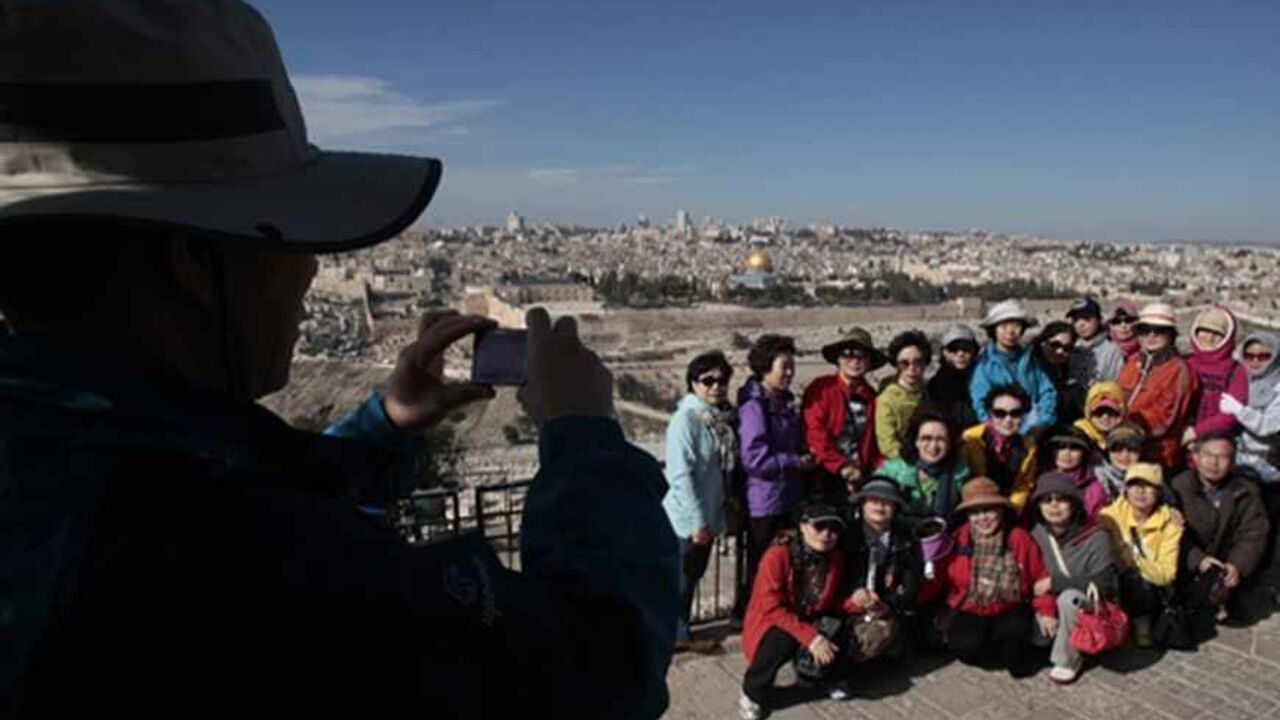PALESTINIANS-ISRAEL/JERUSALEM A group of South Korean tourists have their photo taken at a promenade on the Mount of Olives, that overlooks the Dome of the Rock and Jerusalem's Old City January 12, 2011. According to local businessmen Palestinians have long been hesitant about investing in Arab East Jerusalem, governed by Israel since it occupied the West Bank in 1967 but a small growing number are rising to the challenge, seeing the chance to make a decent return while helping to revive the city's decaying Palestinian economy. To match