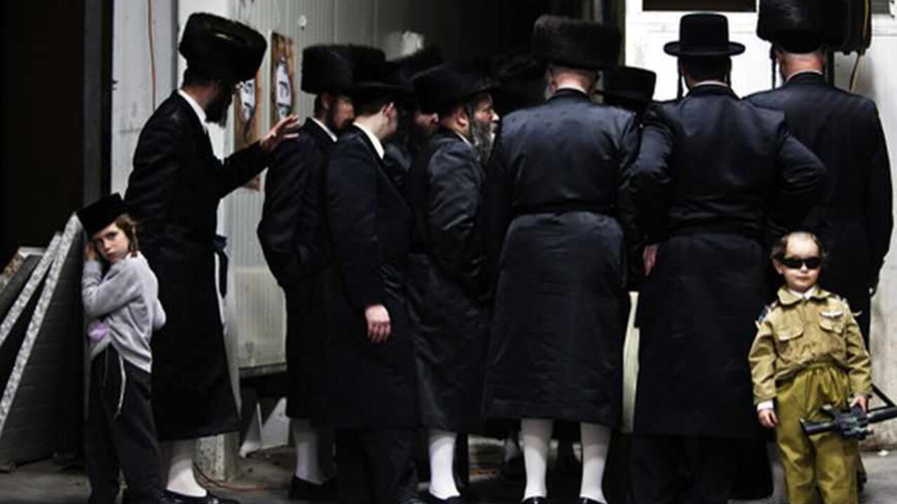 ISRAEL/ An Ultra-Orthodox Jewish boy dressed in a special costume as a soldier for Purim stands next to a group of adults in Bnei Brak February 23, 2013. Purim is a celebration of the Jews' salvation from genocide in ancient Persia, as recounted in the Book of Esther. REUTERS/Nir Elias (ISRAEL - Tags: RELIGION SOCIETY TPX IMAGES OF THE DAY) - RTR3E6W8
