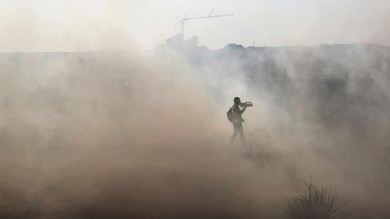Journalist walks through tear gas during clashes in the West Bank village of Bilin near Ramallah A journalist walks through tear gas fired by Israeli security officers (unseen) during clashes with stone-throwing Palestinians following a rally marking the 48th anniversary of the founding of the Fatah movement, in the West Bank village of Bilin near Ramallah January 4, 2013. REUTERS/Ammar Awad (WEST BANK - Tags: POLITICS CIVIL UNREST) - RTR3C3NU