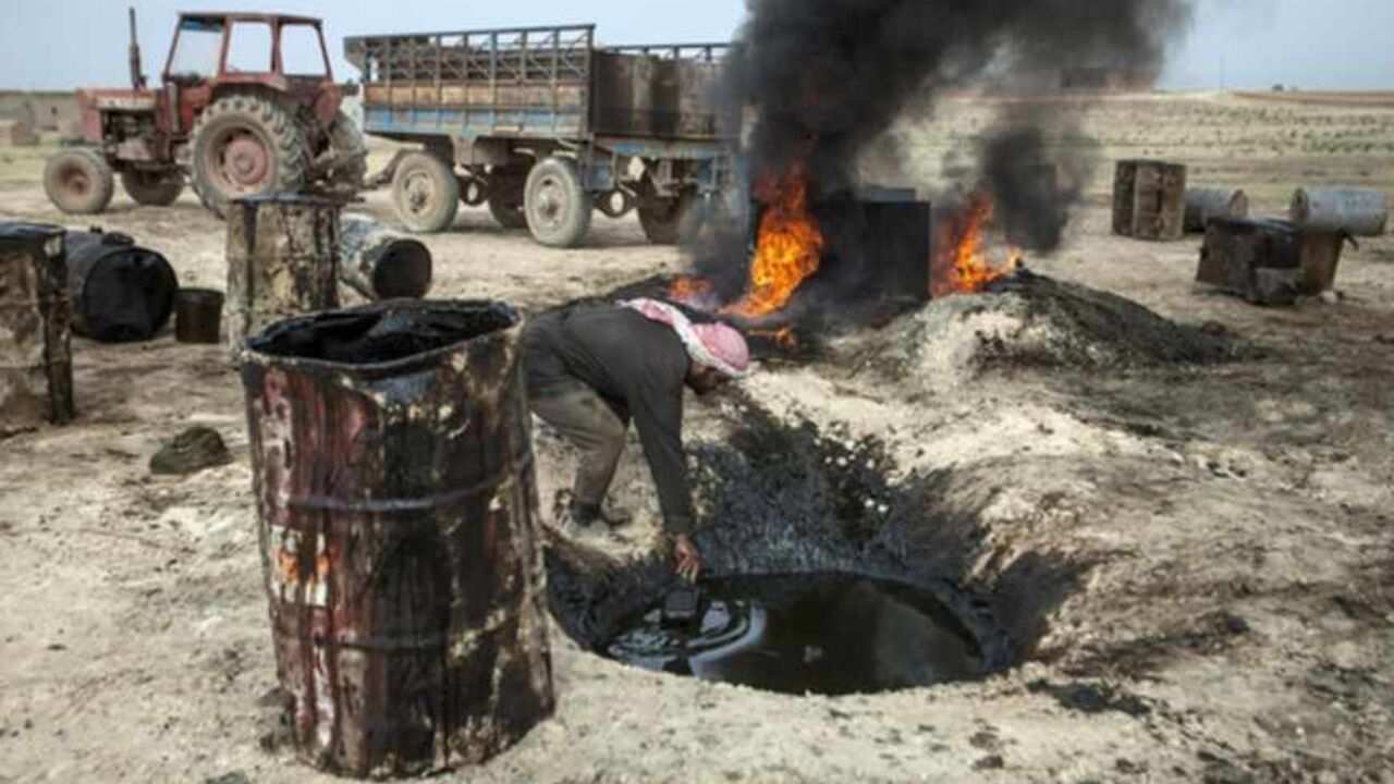 SYRIA-OIL TO GO WITH AFP STORY BY JOSE MIGUEL CALATAYUD
A picture taken on April 15, 2013 shows a Syrian man in the Al Raqqa countryside, who until three months ago was a farmer, pouring crude oil brought from Deir Ezzor province into a pit where it will be distilled as part of the refining process to produce fuel. Final products such as benzine and diesel are then sold to locals. Deir Ezzor contains the largest energy reserves in Syria, which produced some 420,000 of barrels of oil a day before the United States and