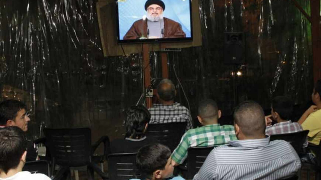 LEBANON-SYRIA-HEZBOLLAH-CONFLICT Lebanese men watch Hezbollah leader Hassan Nasrallah delivering a televised speech at a cafe in Beirut on April 30, 2013. The chief of powerful Lebanese Shiite Muslim party Hezbollah, a close Damascus ally, said that Syria's friends would not let the embattled regime of President Bashar al-Assad fall. AFP PHOTO / ANWAR AMRO (Photo credit should read ANWAR AMRO/AFP/Getty Images)