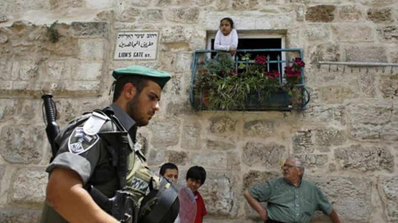 ISRAEL-PALESTINIANS/MUFTI An Israeli border police officer walks past Palestinians in Jerusalem's Old City before a parade marking Jerusalem Day May 8, 2013. Jerusalem Day marks the anniversary of Israel's capture of the Eastern part of the city during the 1967 Middle East War. In 1980, Israel's parliament passed a law declaring united Jerusalem as the national capital, a move never recognised internationally. There were confrontations on Wednesday between Muslims and Jews outside Jerusalem's walled Old City, where al Aqsa mosque is