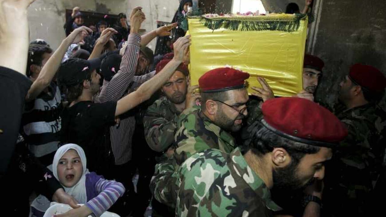 LEBANON/ Supporters of Hezbollah and relatives of Hezbollah members throw rice on a coffin at the funeral of a Hezbollah fighter who died in the Syrian conflict in Ouzai in Beirut May 26, 2013. Hezbollah forces and Syrian President Bashar al-Assad's troops launched a fierce assault last week aimed at driving Syrian rebels out of Qusair, a strategic town close to the Lebanese border that rebels have used as a crucial supply corridor for weapons coming into Syria. REUTERS/Issam Kobeisy (LEBANON - Tags: POLITICS CONFLI