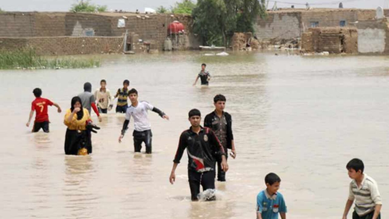 IRAQ-FLOODS People cross a flooded area in Sheikh Saad district, south Baghdad, May 6, 2013. Heavy rains flood villages in southeastern Iraq forcing people to evacuate their homes as waves of water covered streets and houses. Picture taken May 6, 2013. REUTERS/Jaafer Abed (IRAQ - Tags: ENVIRONMENT) - RTXZDIR