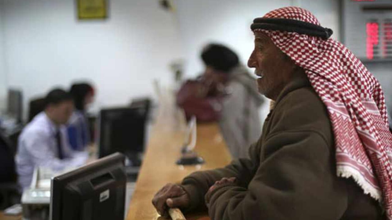 PALESTINIANS-ISRAEL/BANKS A Palestinian man waits at a counter to make a withdrawal at the Housing Bank for Trade & Finance in the West Bank city of Ramallah January 22, 2013. A central bank in the making, the Palestine Monetary Authority (PMA) is a rare bright spot as the economy of the Palestinian territories struggles with Israeli sanctions. Enforcing on Palestinian banks a regimen of conservative lending that has kept bad loans minimal and guaranteed liquidity, the PMA's technocratic prowess is the pinnacle of a Palestinian driv