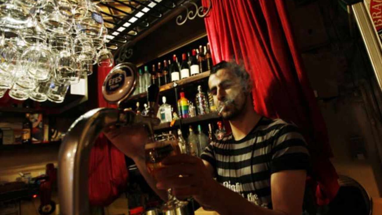 To match Feature TURKEY-SMOKING/BAN Bartender Samet Kardas smokes as he serves beer at a bar in Istanbul July 14, 2009. Smokers in Turkey tempted to flout an imminent ban in cafes, restaurants and bars will be spared execution as allegedly meted out in 17th-Century Istanbul -- but their Prime Minister has likened cigarettes to terrorism. That's a measure of how strongly Tayyip Erdogan feels about tobacco. Sultan Murad IV is said to have roamed the streets ordering the execution of those who defied a smoking ban aimed at curbing coffee house s