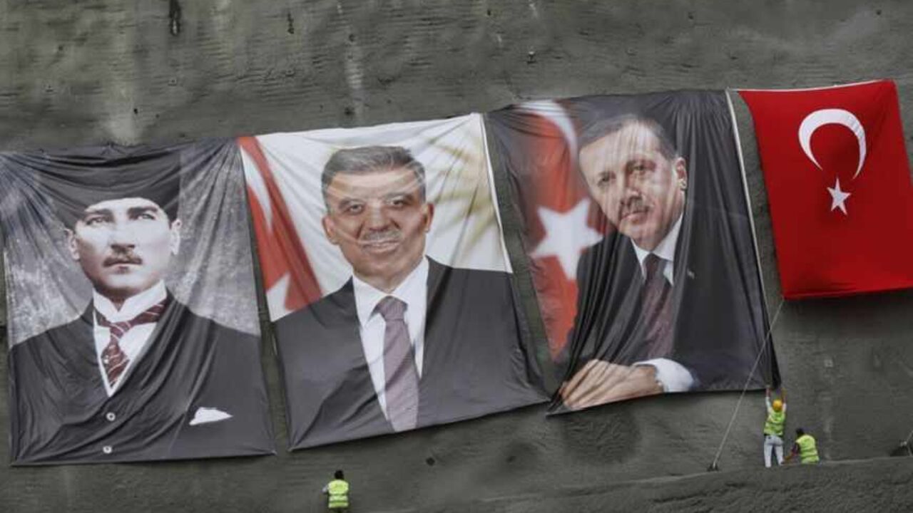 Workers hang portraits of modern Turkey's founder Mustafa Kemal Ataturk (L), President Abdullah Gul (2nd L) and Prime Minister Tayyip Erdogan before a groundbreaking ceremony for the third Bosphorus bridge linking the European and Asian sides of Istanbul May 29, 2013. REUTERS/Murad Sezer (TURKEY - Tags: BUSINESS CONSTRUCTION POLITICS) - RTX1051J