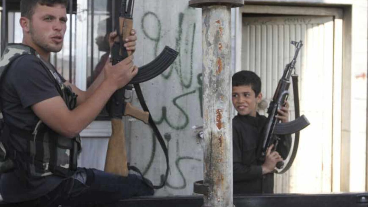 A Free Syrian Army fighter and a boy hold up weapons on a street at the Syrian town of Tel Abyad A Free Syrian Army fighter and a boy hold up weapons on a street at the Syrian town of Tel Abyad, near the border with Turkey, April 23, 2013. Picture taken April 23, 2013. REUTERS/Hamid Khatib (SYRIA - Tags: POLITICS CIVIL UNREST CONFLICT SOCIETY) - RTXYY7Q