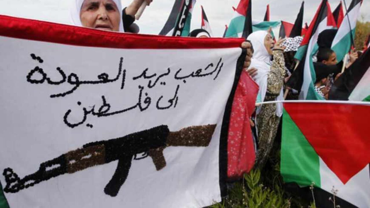 A Palestinian woman holds a banner during a march to mark the 65th anniversary of Nakba near the UNIFIL headquarters in Naqoura, southern Lebanon A Palestinian woman holds a banner bearing the colours of the Palestinian flag that reads, "The people want to return to Palestine", during a march to mark the 65th anniversary of Nakba near the United Nations Interim Force in Lebanon (UNIFIL) headquarters in the town of Naqoura, in southern Lebanon near the border between Lebanon and Israel, May 13, 2013. Palestinians will mark "Nakba" (Catastrophe) on May 15 to commemorate the expulsion or fleeing of hundreds of thousands of their brethren from their home