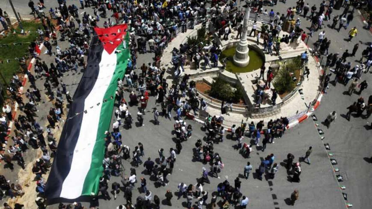 Palestinians carry a giant Palestinian flag through central Ramallah during a rally to mark Nakba Day in the West Bank city of Ramallah Palestinians carry a giant Palestinian flag through central Ramallah during a rally to mark Nakba Day in the West Bank city of Ramallah May 15, 2013. Palestinians clashed with Israeli forces in the occupied West Bank and at East Jerusalem on Wednesday during demonstrations to mark 65 years since what they call the Nakba (Catastrophe) when Israel's creation caused many to lose their homes and become refugees. REUTERS/Mohamad Torokman (WEST BANK - Tags: CIVIL UNREST POLITICS ANNIVERSARY) - RTXZNF8