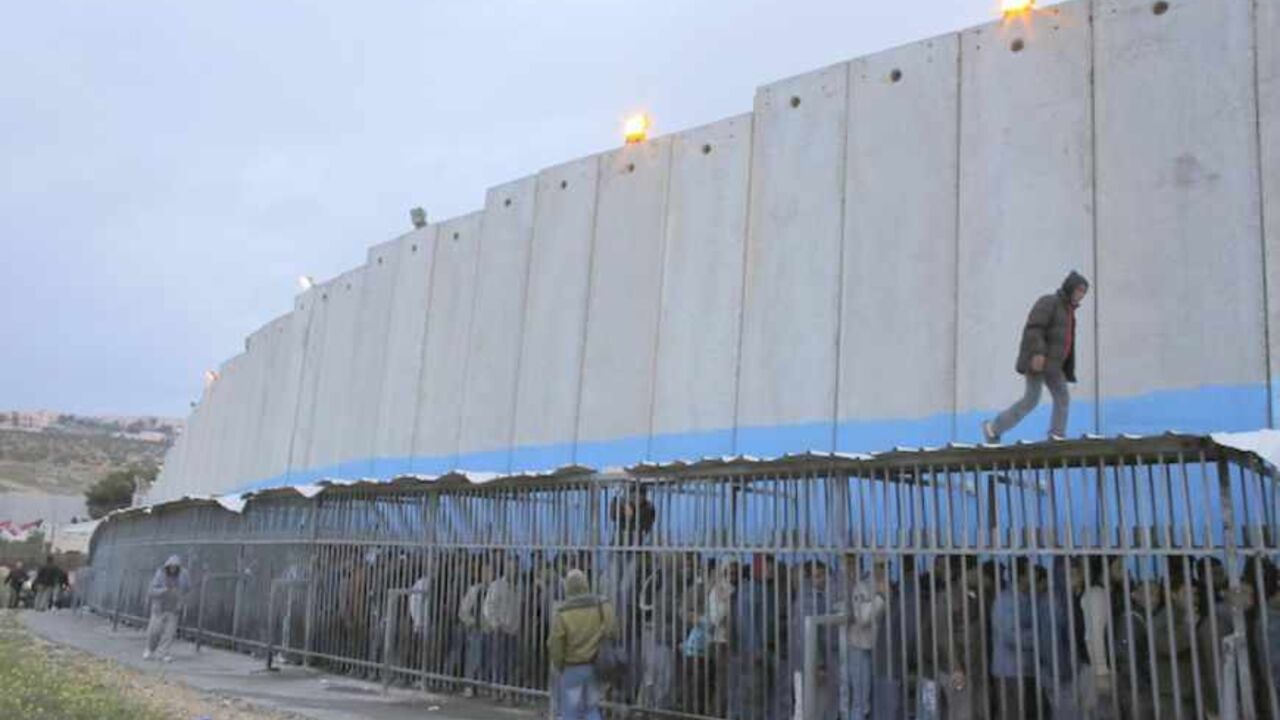 Palestinian labourers queue next to a section of the controversial Israeli barrier as they wait to cross into Jerusalem at an Israeli checkpoint in Bethlehem Palestinian labourers queue next to a section of the controversial Israeli barrier as they wait to cross into Jerusalem at an Israeli checkpoint in the West Bank town of Bethlehem March 18, 2013. U.S. President Barack Obama is due to make his first official visit to Israel and the Palestinian Territories this week, looking to improve ties after sometimes rocky relations with both sides during his first term in office. Israeli settlement expansion lies at the heart of much of the rancour between Israeli Prim