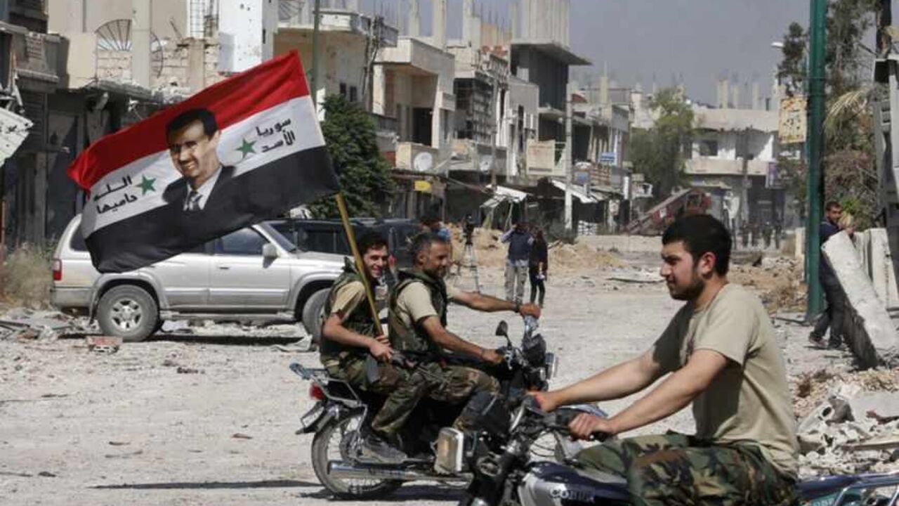 Forces loyal to Syria's President Bashar al-Assad carry the national flag as they ride on motorcycles in Qusair, after the Syrian army took control from rebel fighters, June 5, 2013. Syrian government forces and their Lebanese Hezbollah allies seized control of the border town of Qusair on Wednesday, dealing a major defeat to rebel fighters battling to overthrow Assad. REUTERS/Mohammed Azakir (SYRIA - Tags: CONFLICT MILITARY POLITICS CIVIL UNREST) - RTX10CO4
