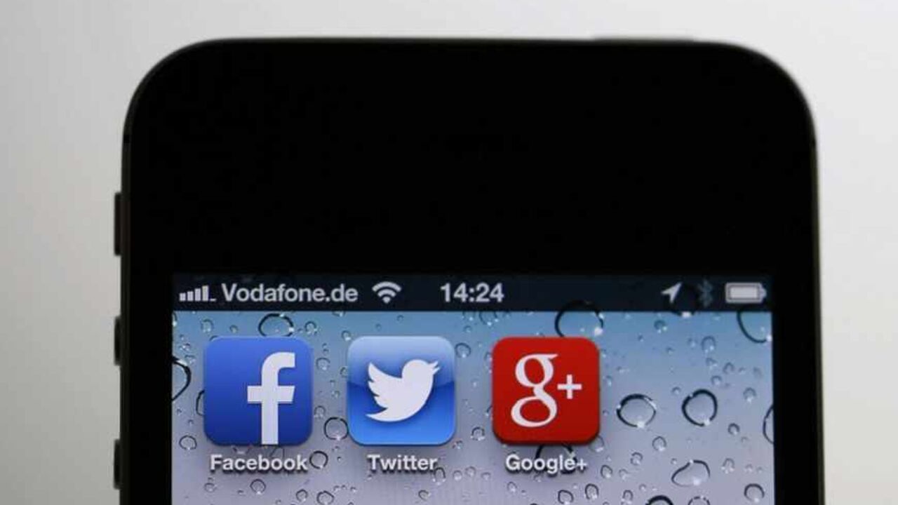 The application icons of Facebook, Twitter and Google are displayed on an iPhone next to an earphone set in this illustration photo taken in Berlin, June 17, 2013. European firms believe revelations that the U.S. National Security Agency (NSA) PRISM programme secretly gathered user data from nine big U.S. Internet companies, including Microsoft and Google, will hand them a competitive advantage as they play catch-up with the dominant American players in "cloud computing".  REUTERS/Pawel Kopczynski (GERMANY 