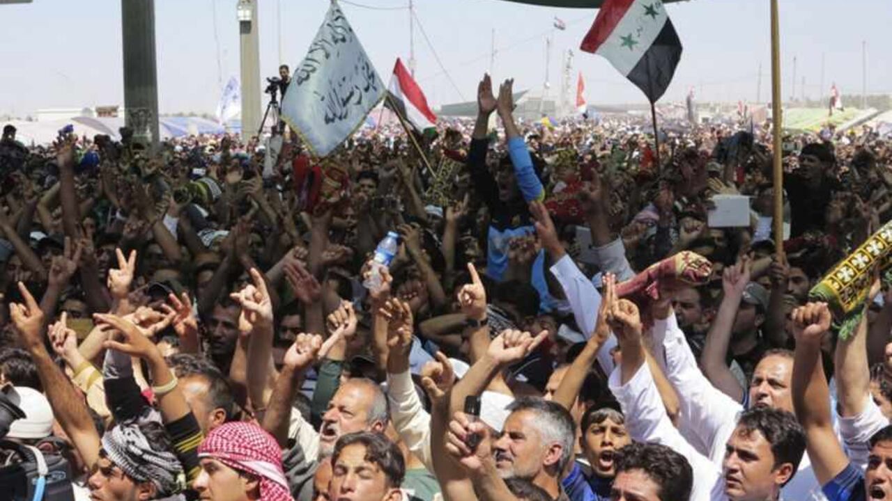 Sunni Muslims chant as they wave old Iraqi flags during an anti-government demonstration in Ramadi Sunni Muslims chant "Allahu Akbar", meaning "God is great", as they wave old Iraqi flags during an anti-government demonstration in Ramadi, 100 km (62 miles) west of Baghdad, April 26, 2013. Tens of thousands of Sunni Muslims poured onto the streets of Ramadi and Falluja in the western province of Anbar following Friday prayers, in protest against the perceived marginalisation of their sect since the U.S.-led invasion overthrew Saddam Hussein and empowered majority Shi'ites through the ballot box. REUTERS/