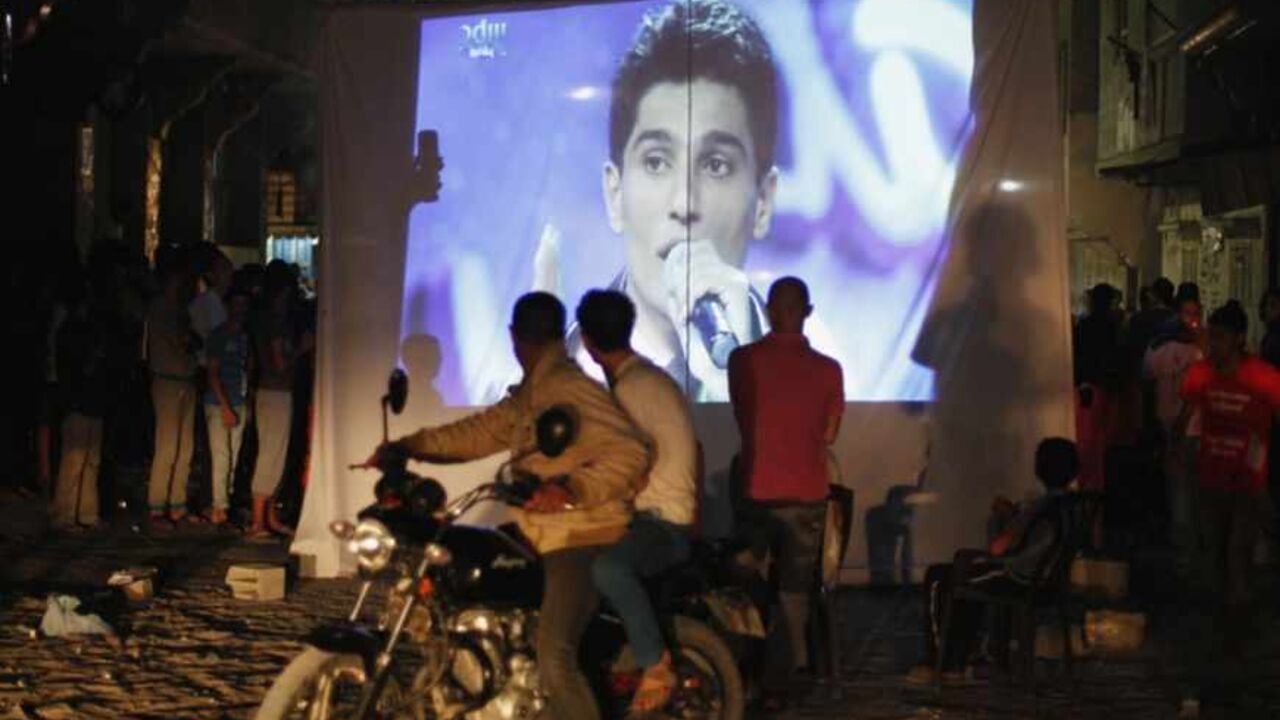 People watch Palestinian singer Assaf as he sings in Beirut during the "Arab Idol" program, in Khan Younis People watch Palestinian singer Mohammed Assaf as he sings in Beirut during the "Arab Idol" program, in Khan Younis in the southern Gaza Strip June 22, 2013. The 22-year-old singer Mohammed Assaf, from the Gaza Strip, was named the winner of "Arab Idol" in a TV talent contest in Beirut. REUTERS/Ibraheem Abu Mustafa (GAZA - Tags: SOCIETY ENTERTAINMENT) - RTX10XJ1